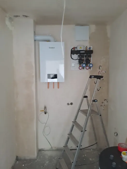 Biały kocioł gazowy na ścianie podczas wykonywania instalacji